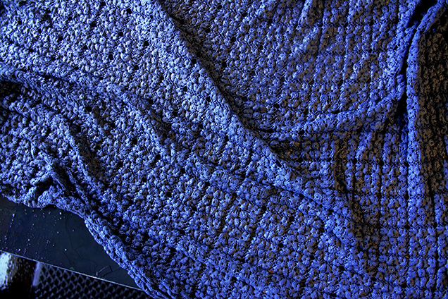 A blue blanket on a black surface.